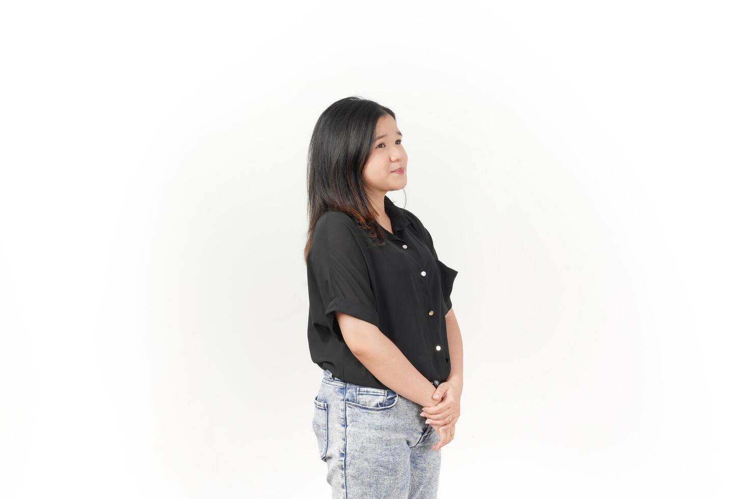beautiful Asian woman stands in a thoughtful pose, lost in contemplation against a white background photo
