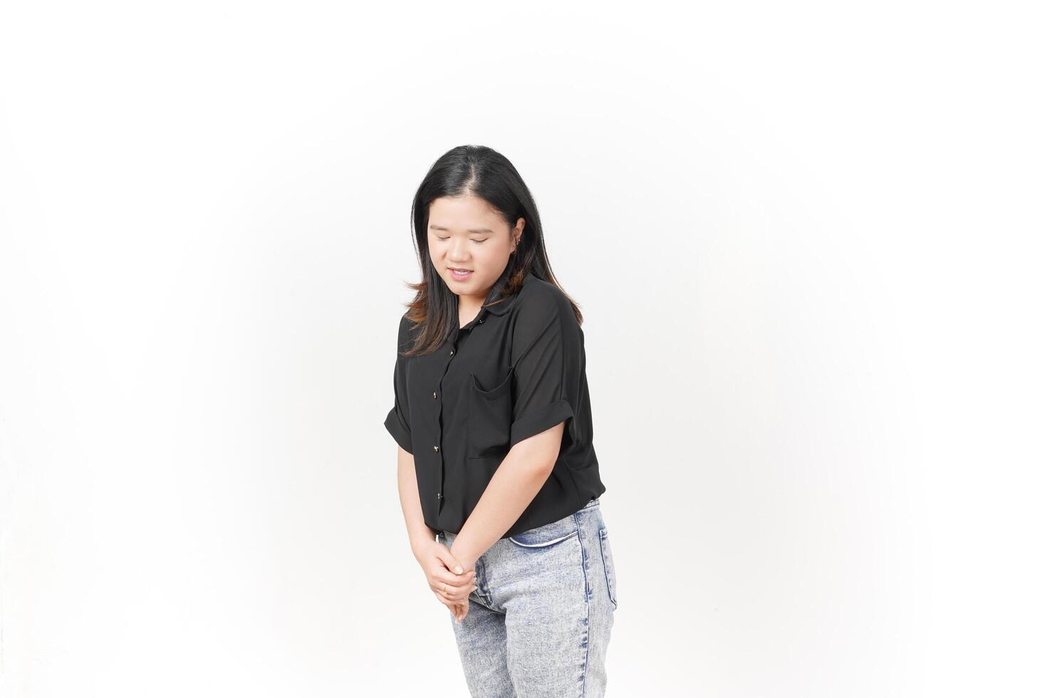 beautiful Asian woman stands gracefully, looking down thoughtfully against a clean white background photo