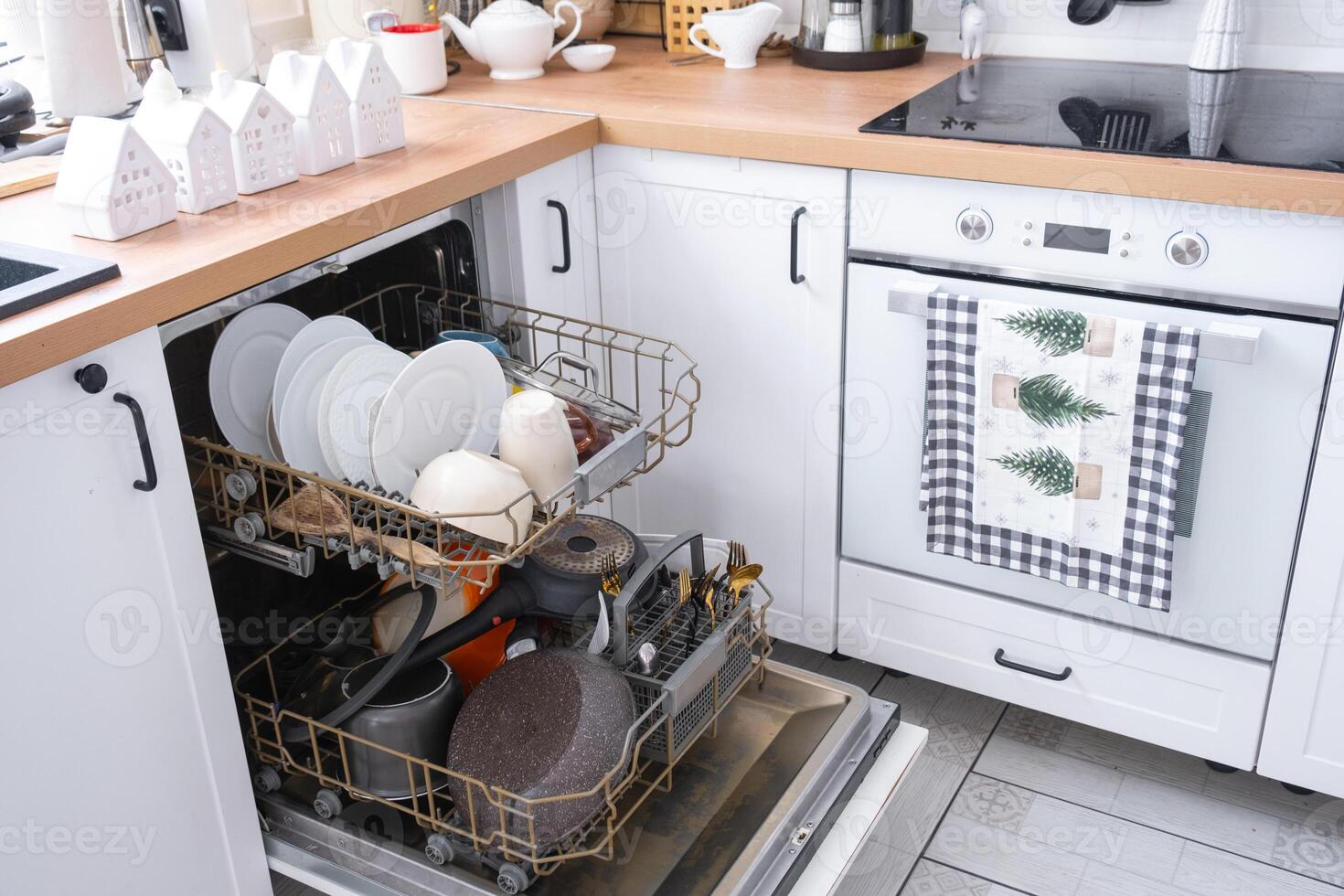 A lot of dirty dishes in the dishwasher in the festive kitchen. Helping the hostess, economy and ecology. Cleaning in the kitchen for the holidays of Christmas and New Year, after the feast and guests photo