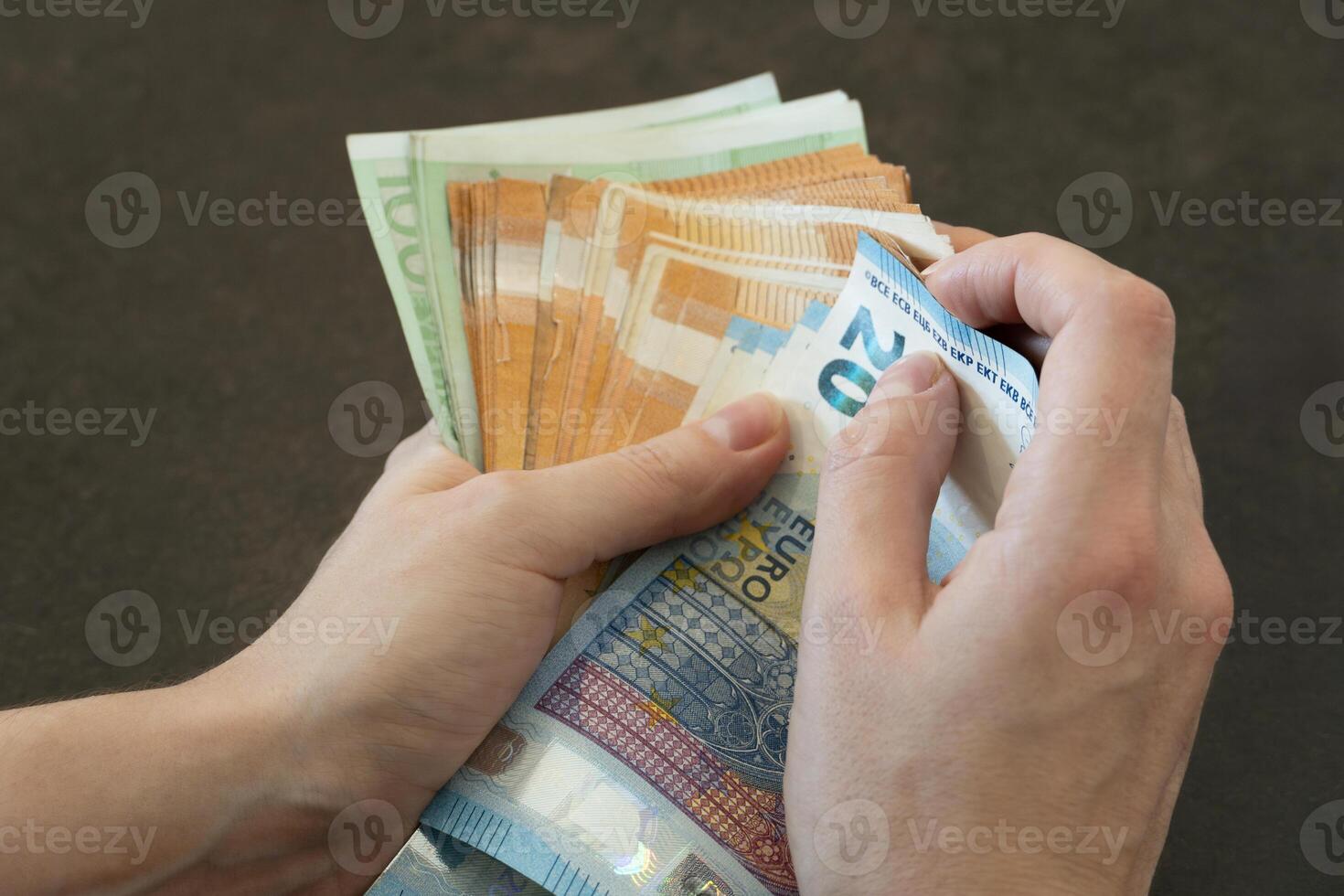 Close-up of woman's hands counting euro banknotes photo