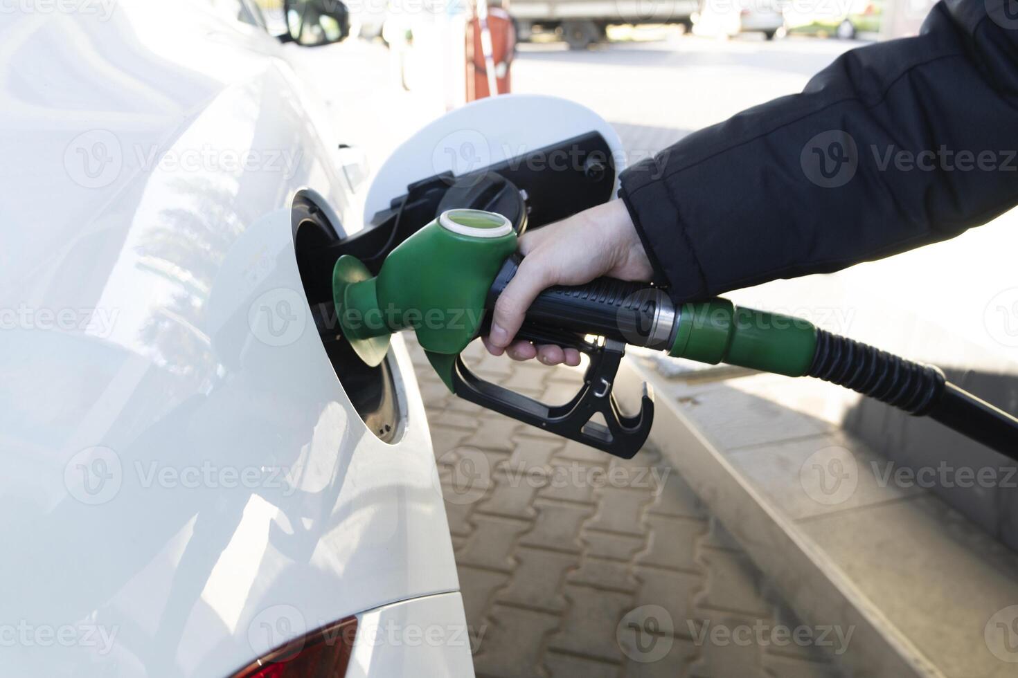 Man Refueling the car at a gas station fuel pump. Hand refilling and pumping gasoline oil the car. photo