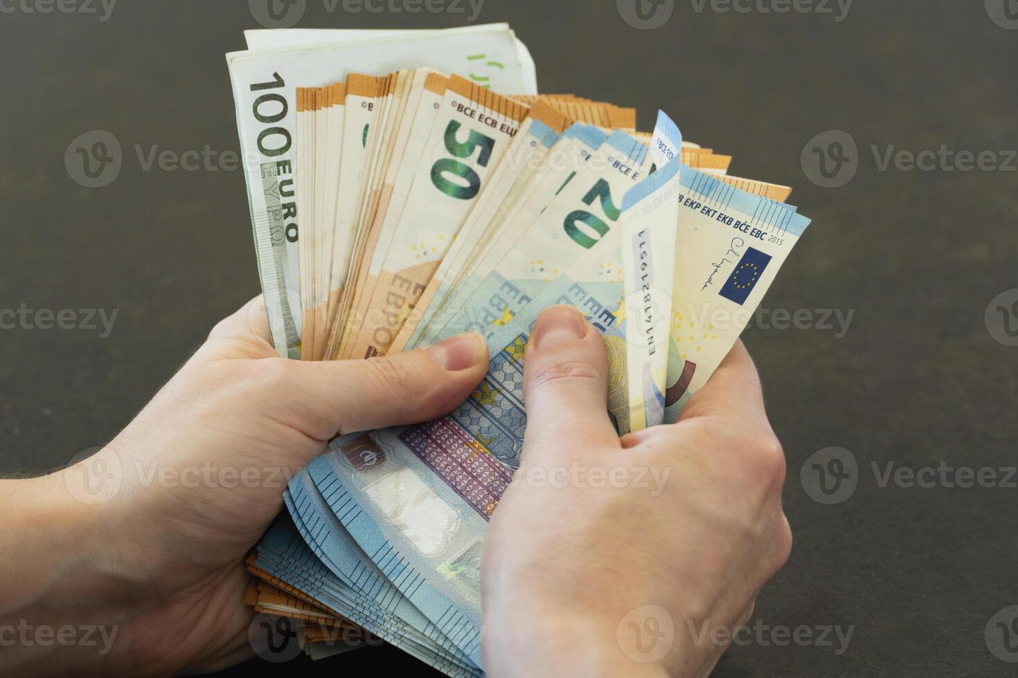 Close-up of woman's hands counting euro banknotes photo