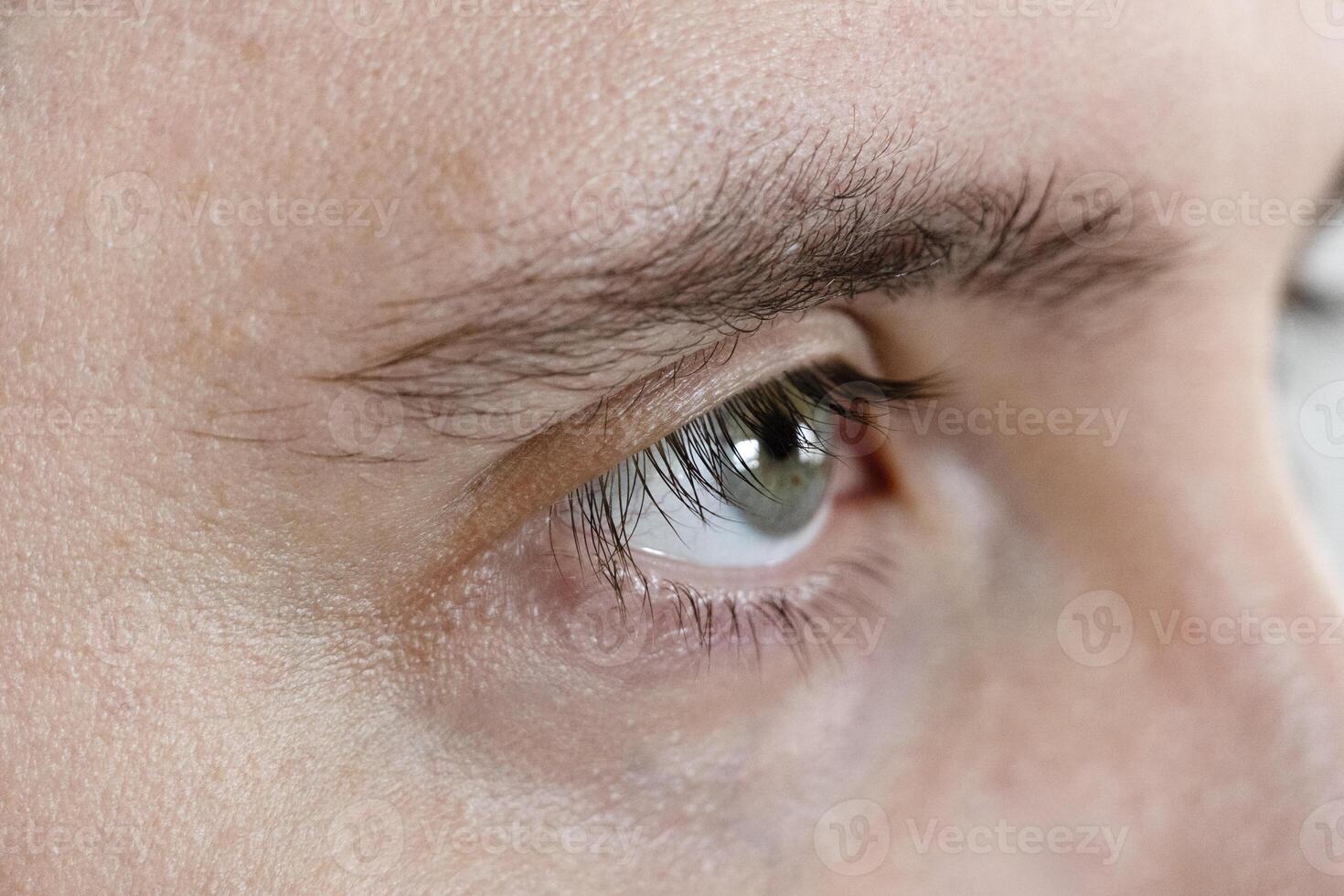 Macro Studio Expression Shot Of man's green Eye With Close Up On Eyelashes And Pupil photo