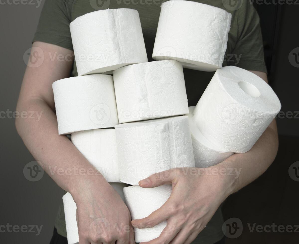 Man are stocking up toilet paper for home. Holding many rolls of toilet paper photo