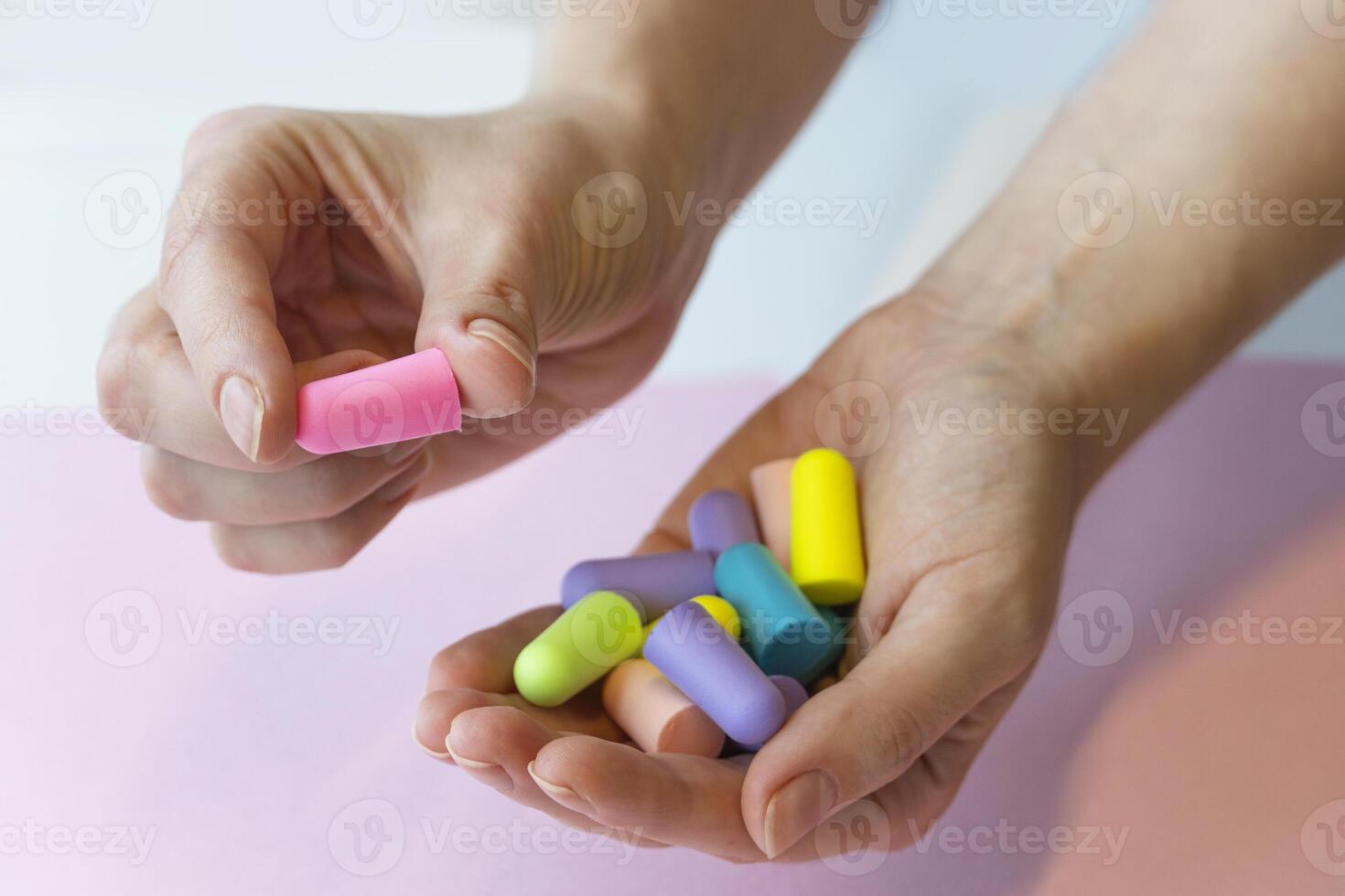 group of colorful ear plugs noise reduction sleep quiet jar, woman's hands holding earplugs photo
