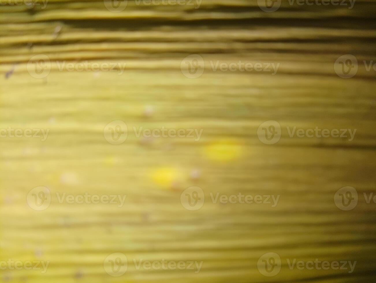 Close-up of textured yellow fibers, possibly from a plant or natural material, showcasing a blurred background with subtle variations in color and light. photo