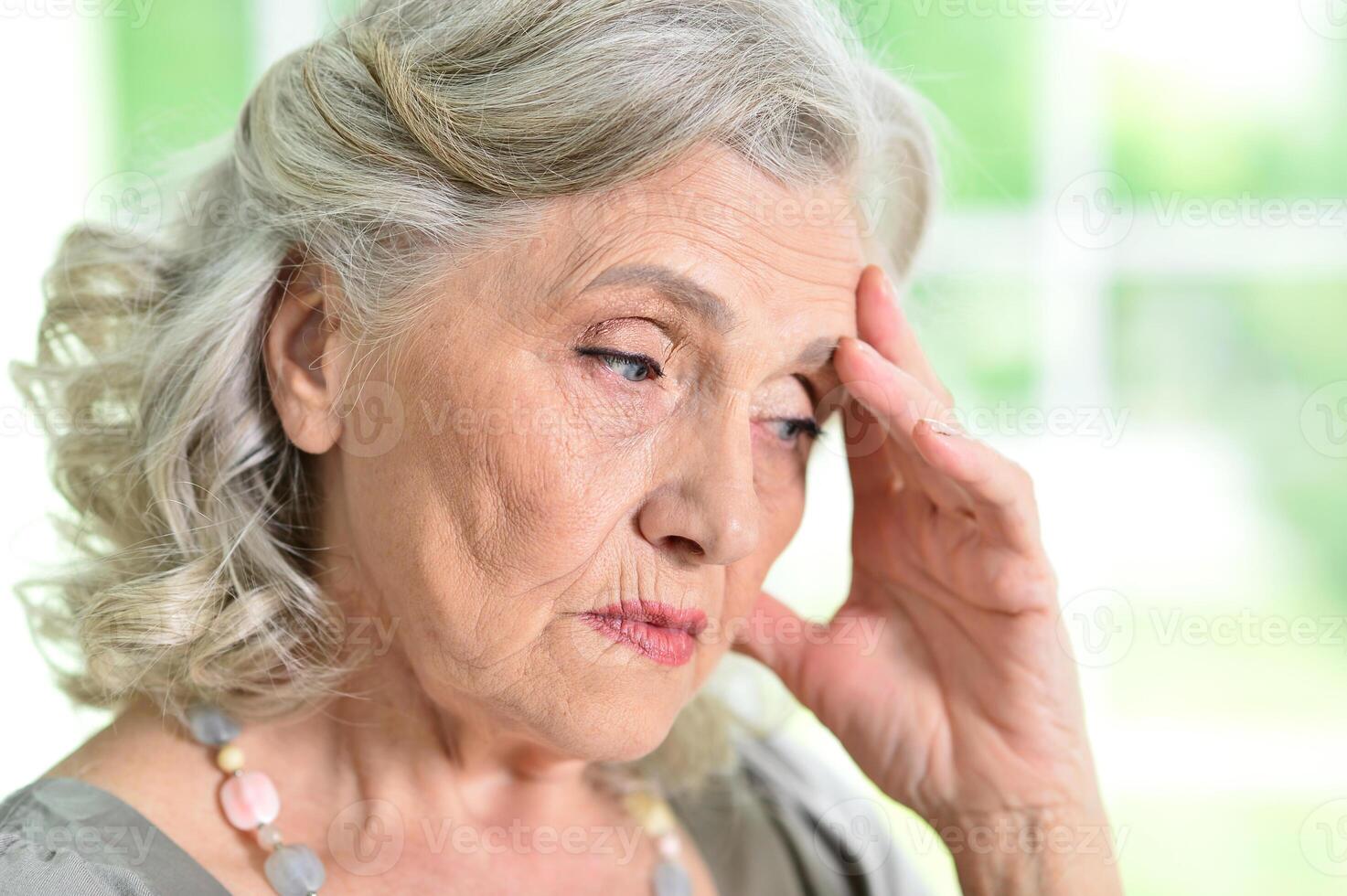 Close up portrait of sad senior woman at home photo