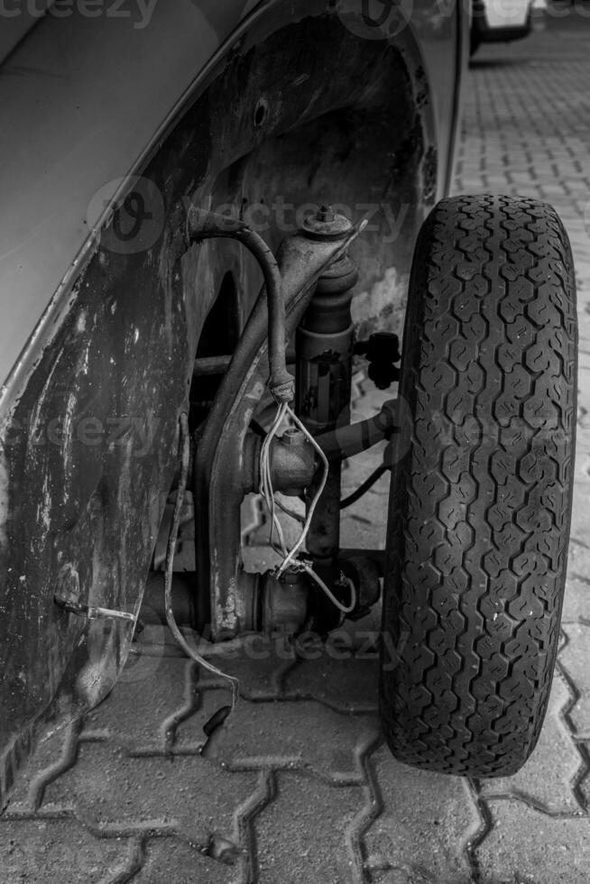Close-up view of an old car's front wheel and suspension system photo