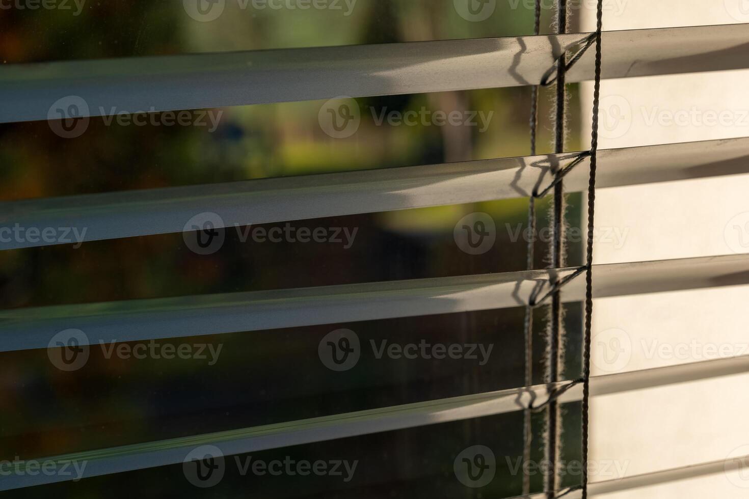 Sunlight filtering through closed blinds in a tranquil indoor space during the early morning hours photo