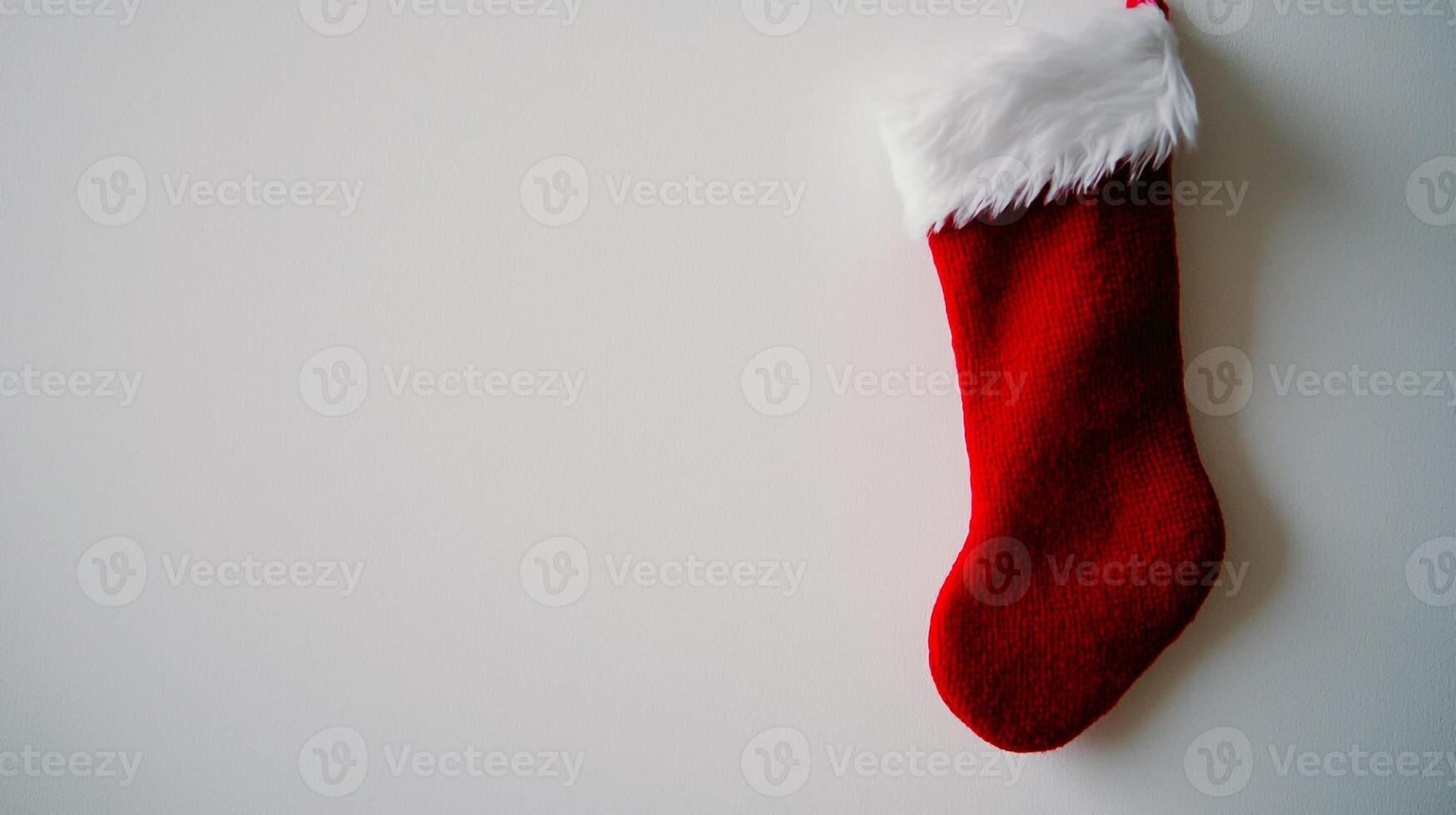 A red and white christmas stocking hanging on a wall photo