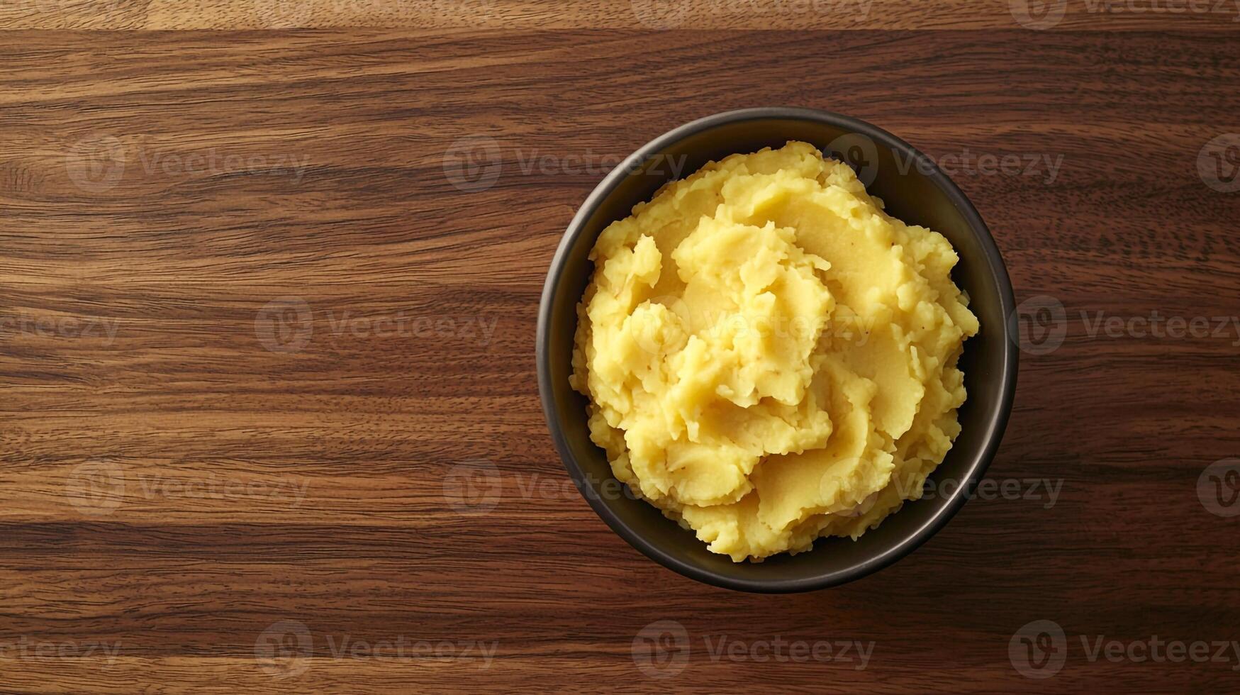 A bowl of mashed potatoes on a wooden table photo