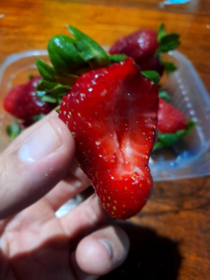 A person holding a strawberry photo