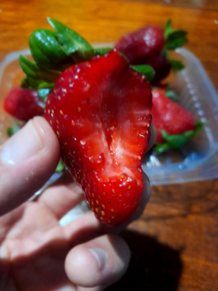 A person holding a strawberry photo