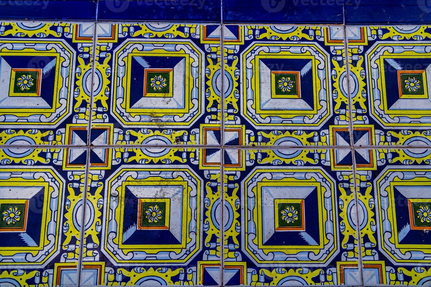 A collection of decorative ceramic tiles displays an array of intricate patterns and vibrant colors, including blues and greens photo