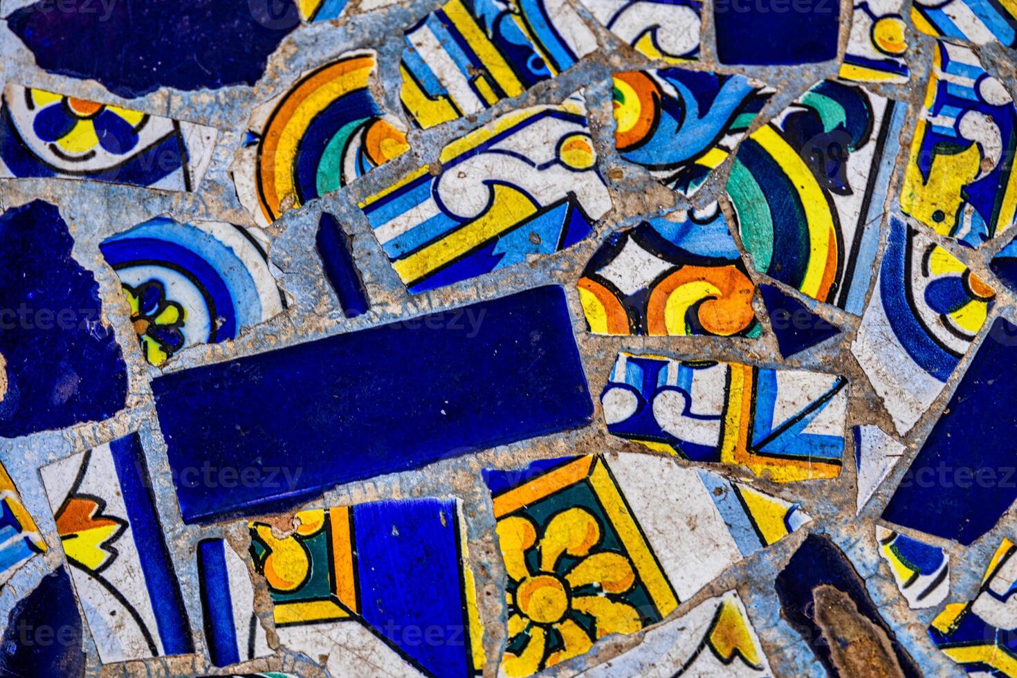 A blue collection of decorative ceramic tiles displays an array of intricate patterns and vibrant colors, including blues, reds, and greens photo