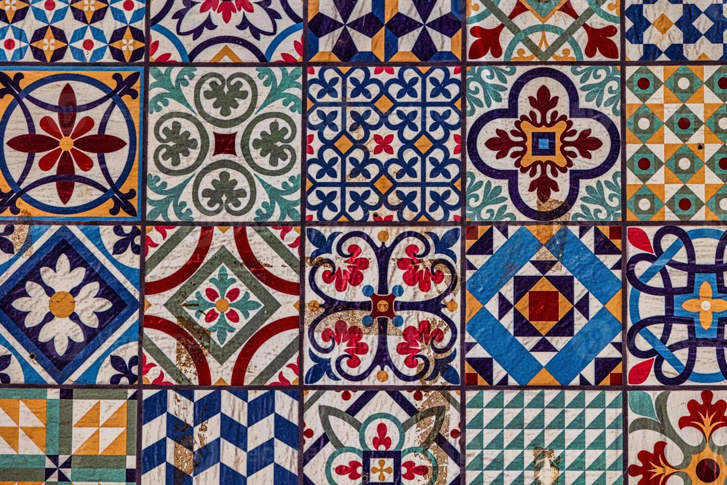 A collection spanish of decorative ceramic tiles displays an array of intricate patterns and vibrant colors, including blues, reds, and greens photo