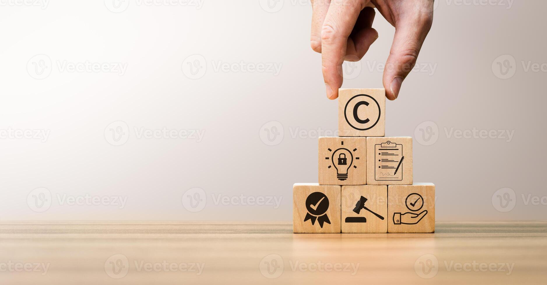 Hand Arranging Wooden Blocks with Copyright Symbol, Legal Icons Representing Intellectual Property Protection, Innovation, and Business Compliance in Law, Creativity, and Trademark Ownership Concepts photo