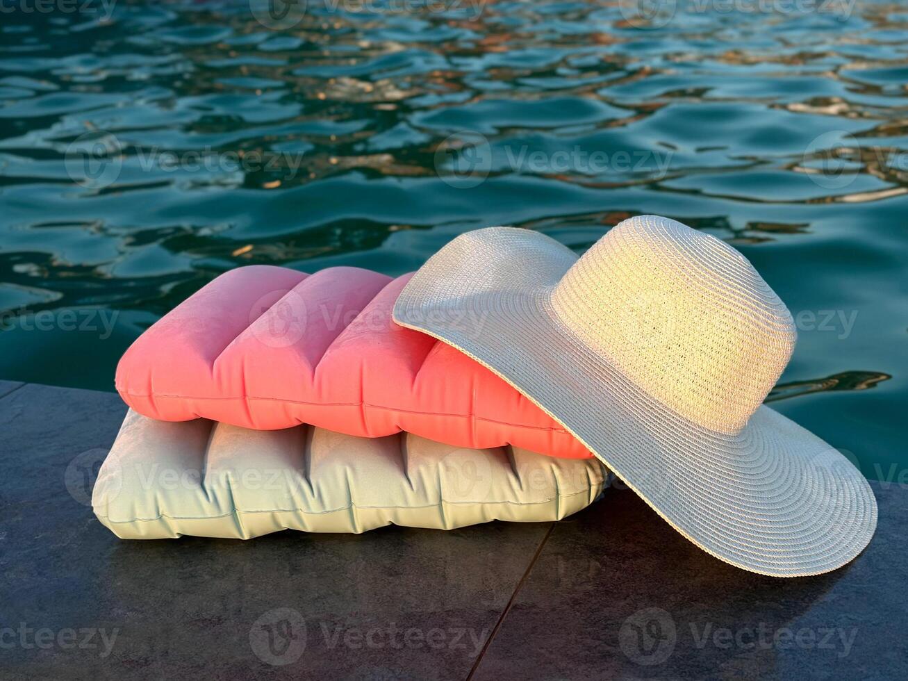 Inflatable pillows by the pool. A large beach hat on pillows. photo