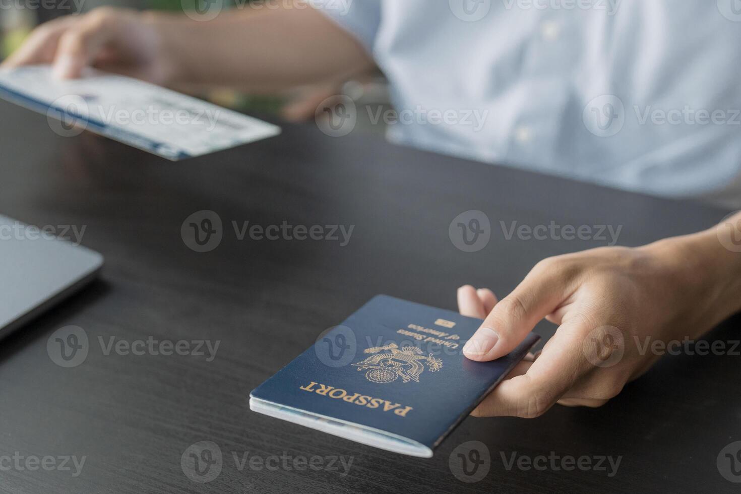 Hand Man Online booking and buying plane tickets using laptop phone and credit card Planning trip travel vacation with passport and ticket photo