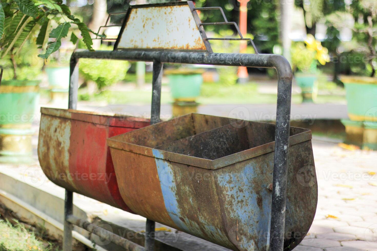 Rusty Dual Trash Bins in a Park with Greenery in Background photo