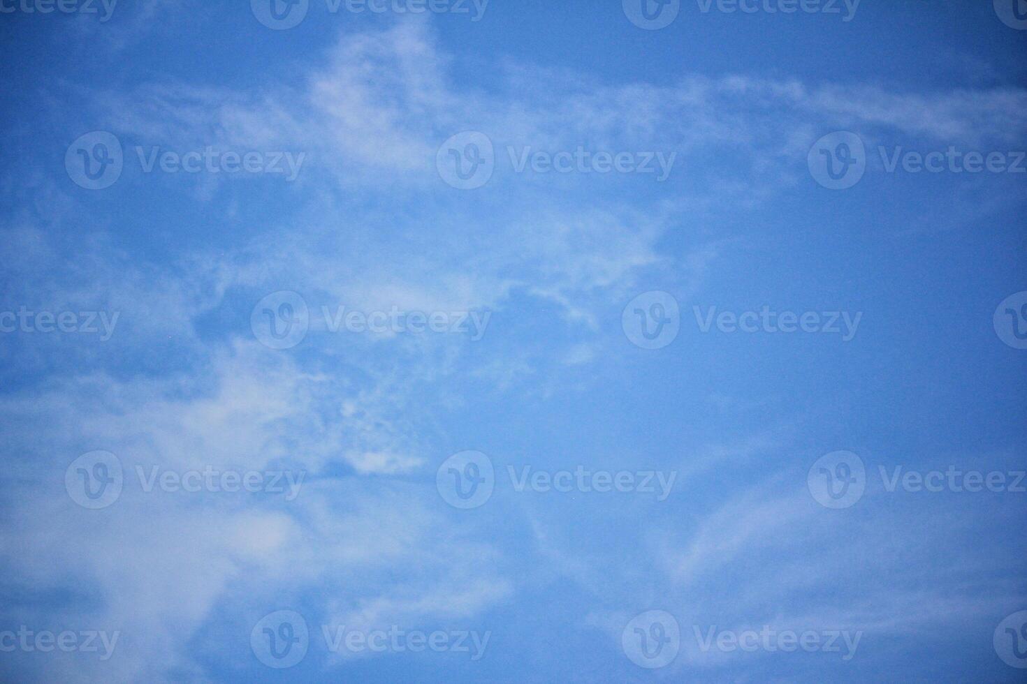 Clear Blue Sky with Soft White Clouds Captured on a Sunny Day photo