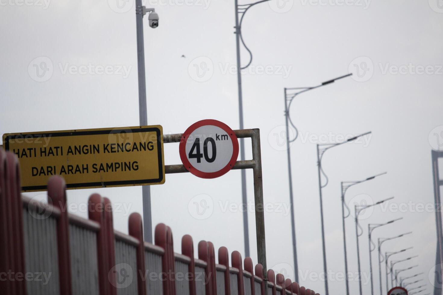 Speed Limit Warning Sign and Strong Side Wind Alert on Bridge photo