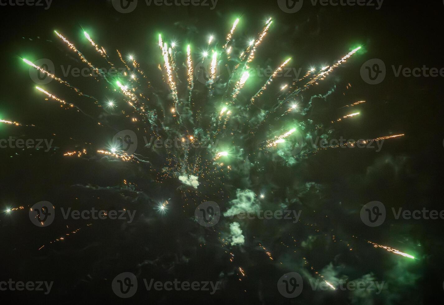 Green fireworks sparks exploding on the dark sky photo
