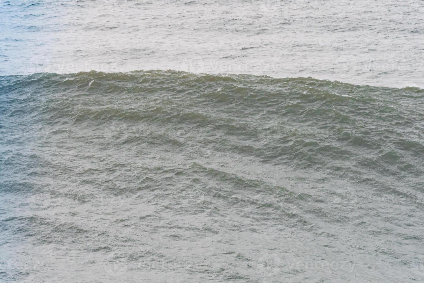 A massive ocean wave cresting with a textured surface in Nazare, Portugal photo