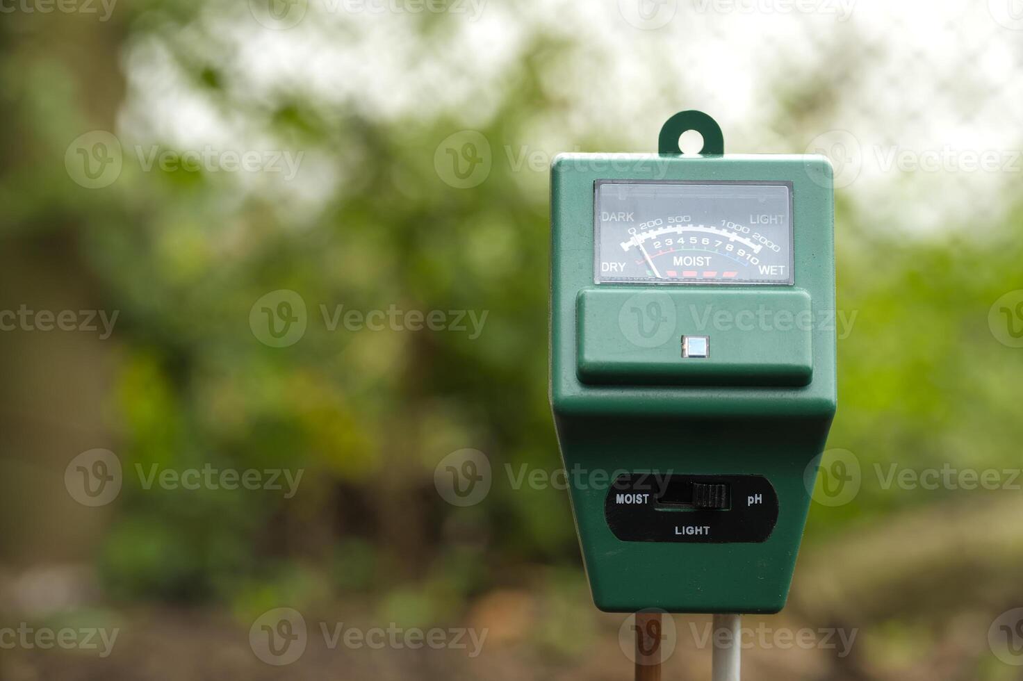 Close-up of a soil moisture and pH meter in a garden setting to monitor plant care conditions photo