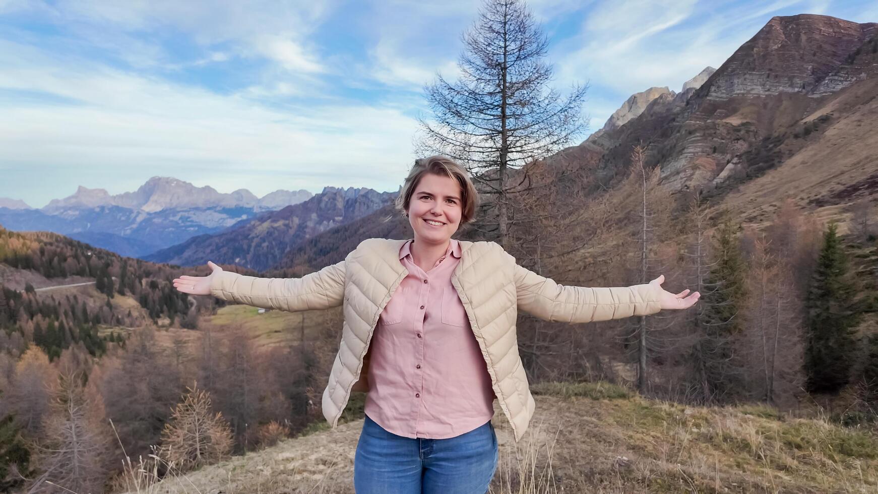 A Caucasian woman enjoys a scenic mountain view during an autumn hike, symbolizing freedom and appreciation of natures beauty photo