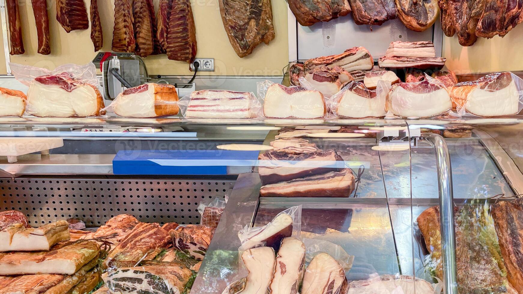 Variety of cured meats displayed in a traditional European butcher shop, ideal for Christmas feasts or gourmet cooking concepts photo