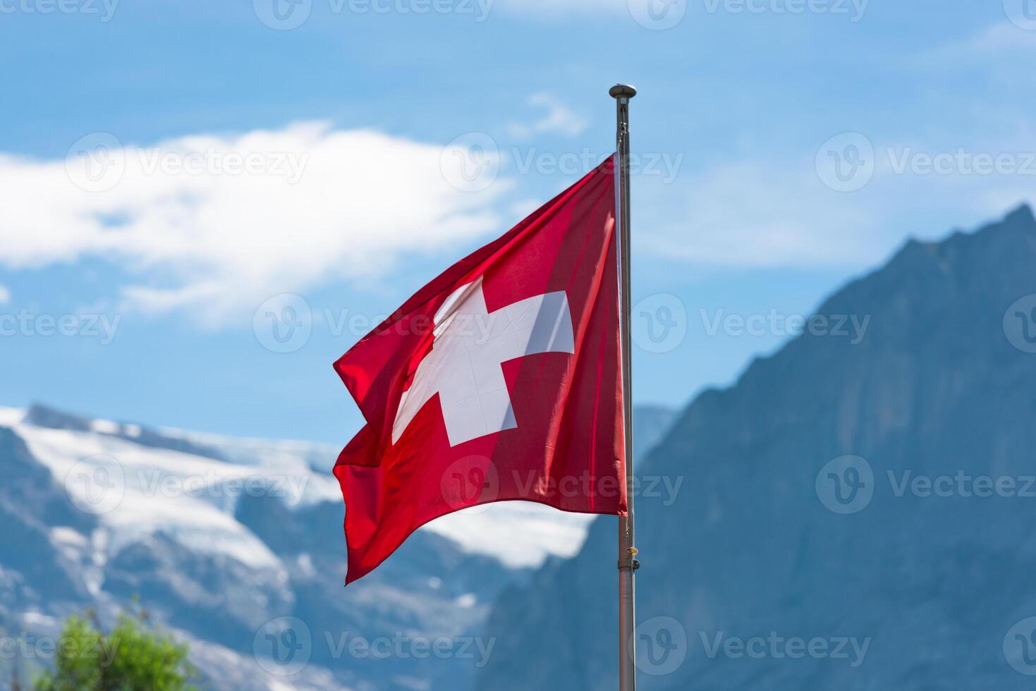 Swiss flag against Alps mountains photo