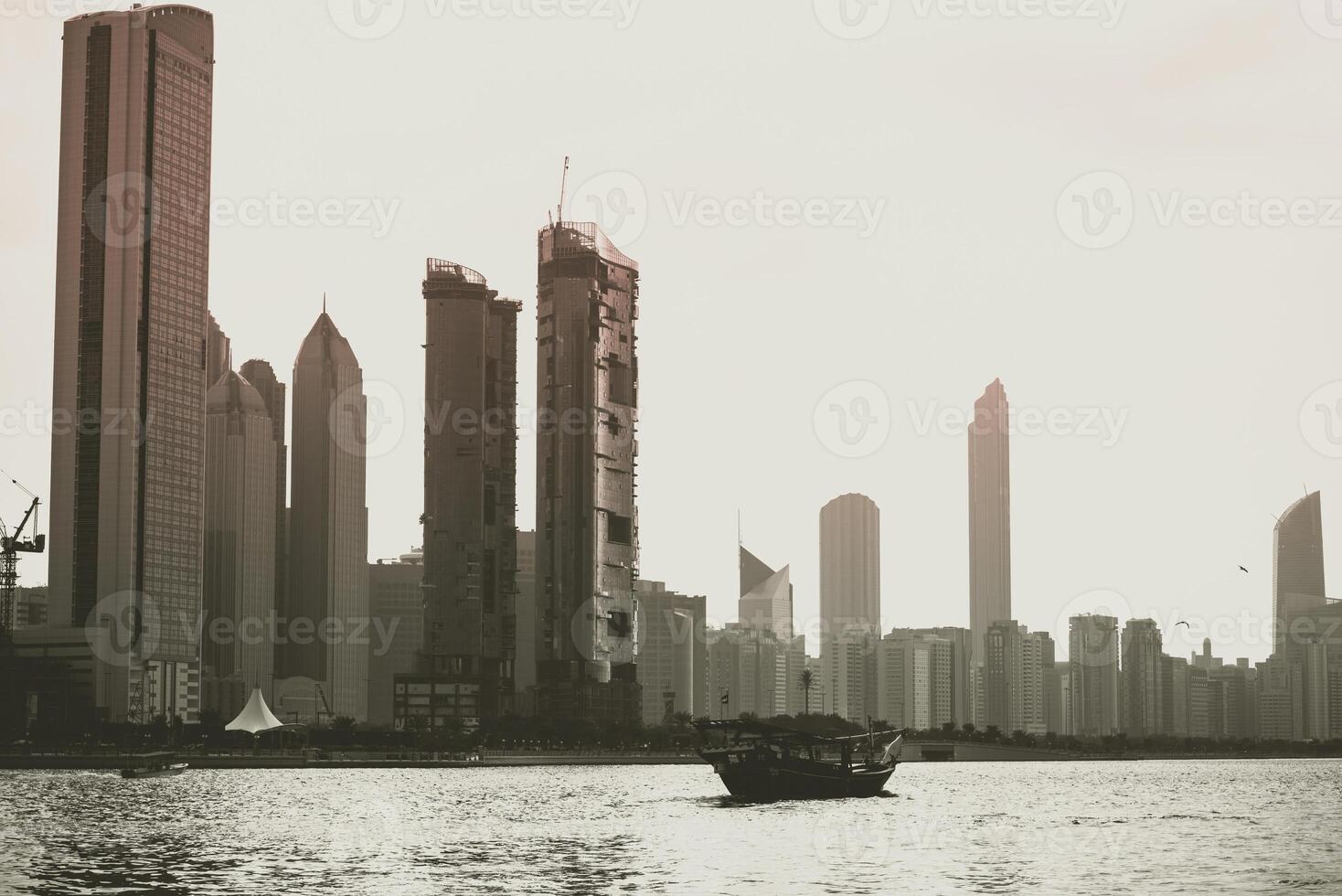 Abu Dhabi buildings skyline with old fishing boat photo