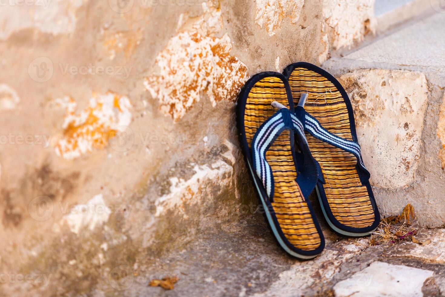 Beach flip-flops on the old wall background photo