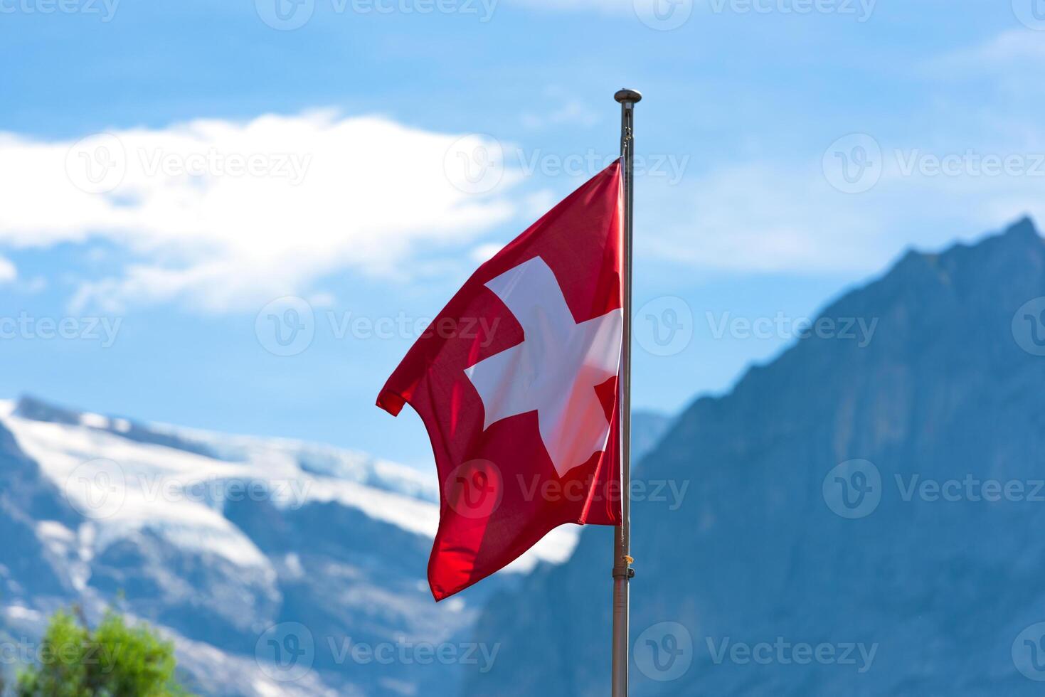 Swiss flag against Alps mountains photo