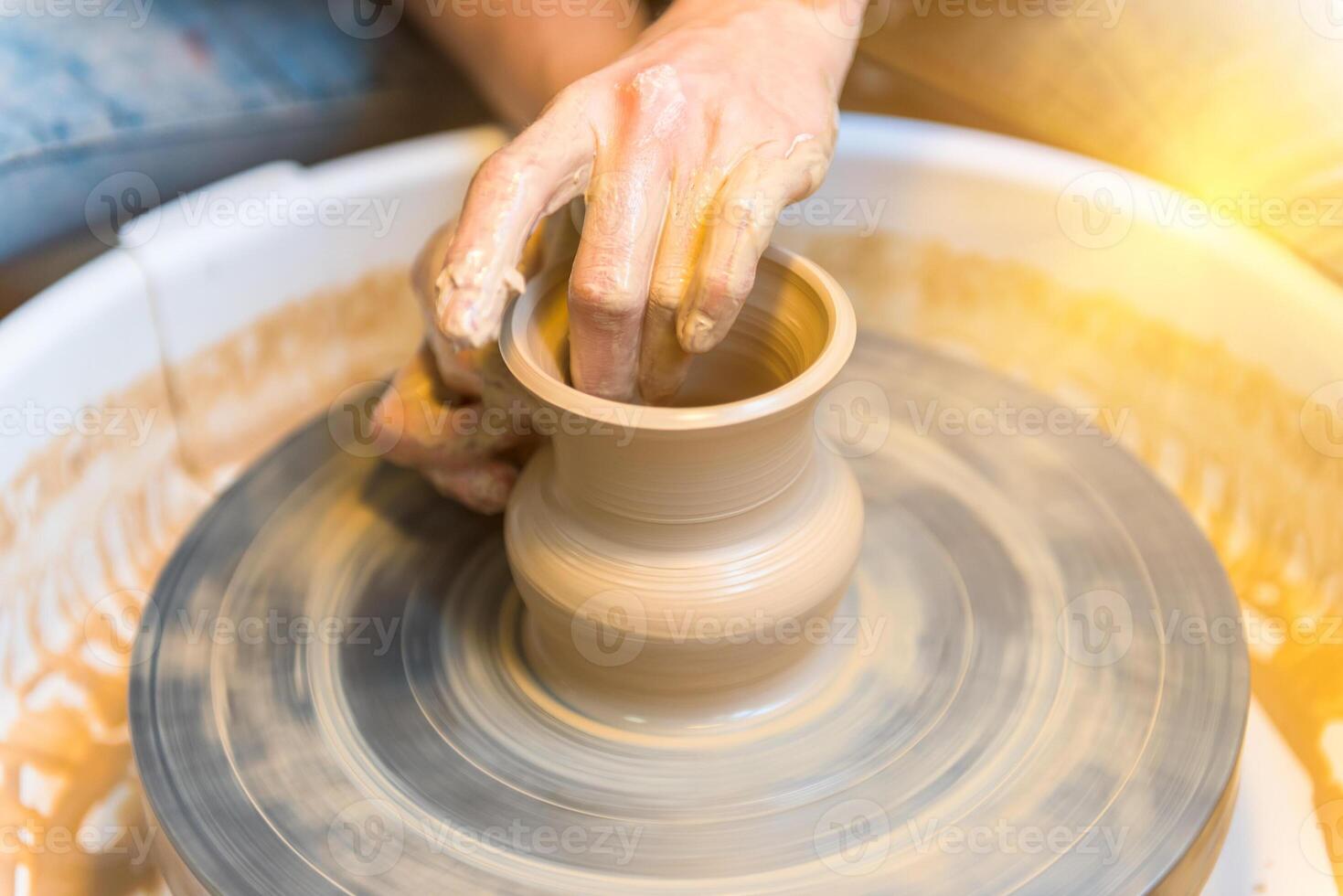 womens hands of a potter creating an earthen jar photo