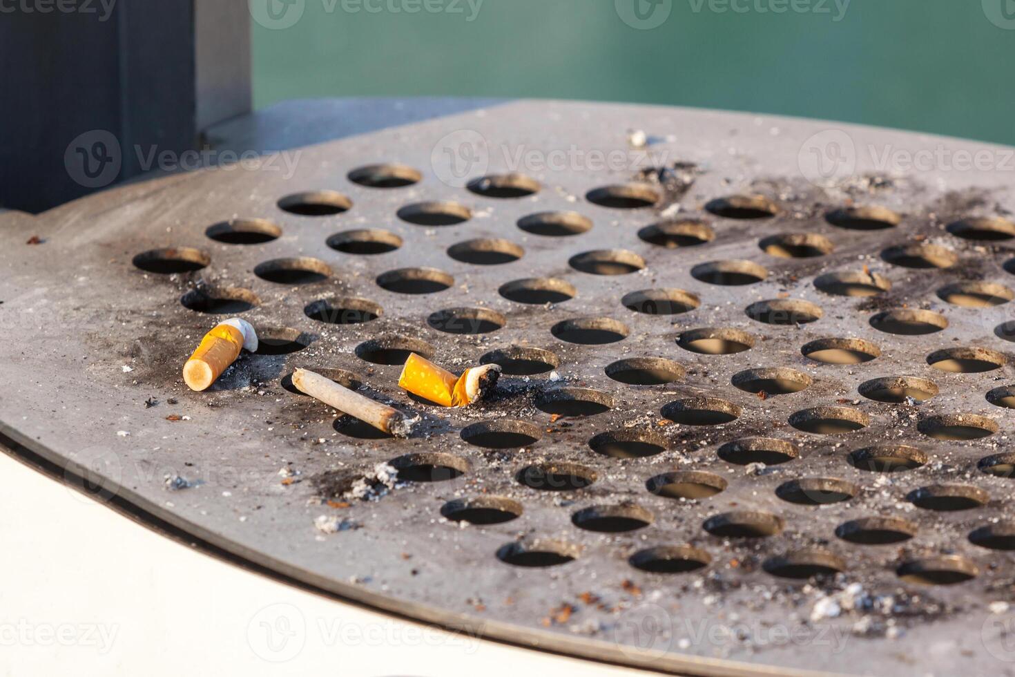 Smoked cigarettes in a dirty outdoors ash-tray photo