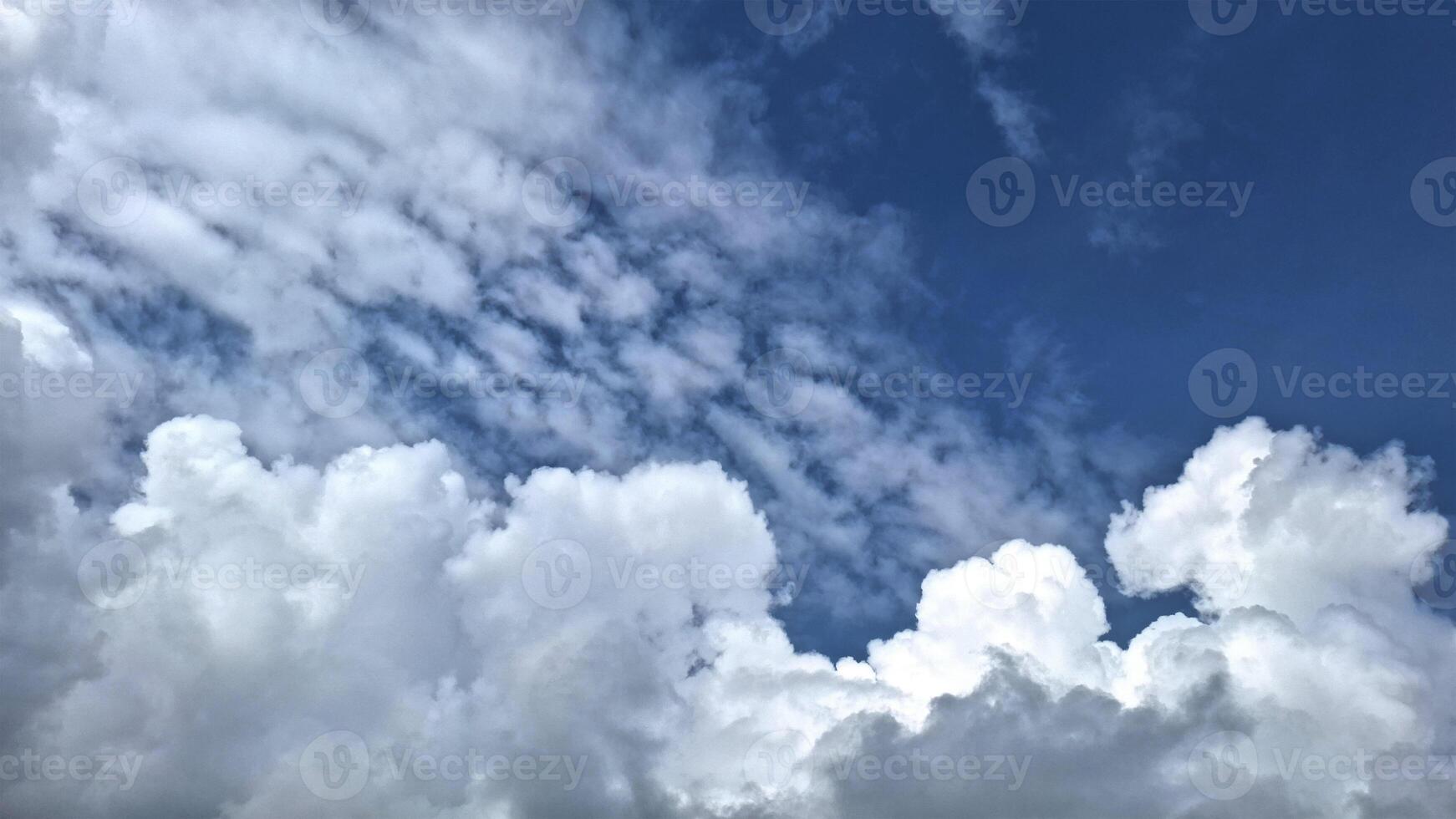 The beautiful pattern formed by white clouds in the blue sky looks dramatic. The combination of blue and white creates a calming and pleasant scene. photo