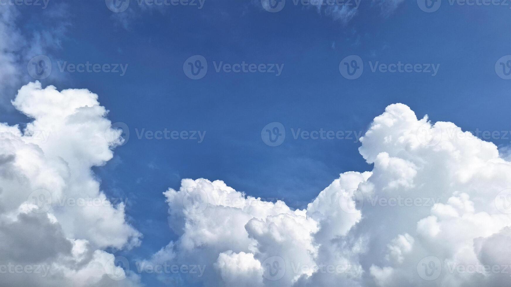 The bright sky view is adorned with clouds that look like cotton with blue sky background. This scene provides a feeling of peace and coolness. photo