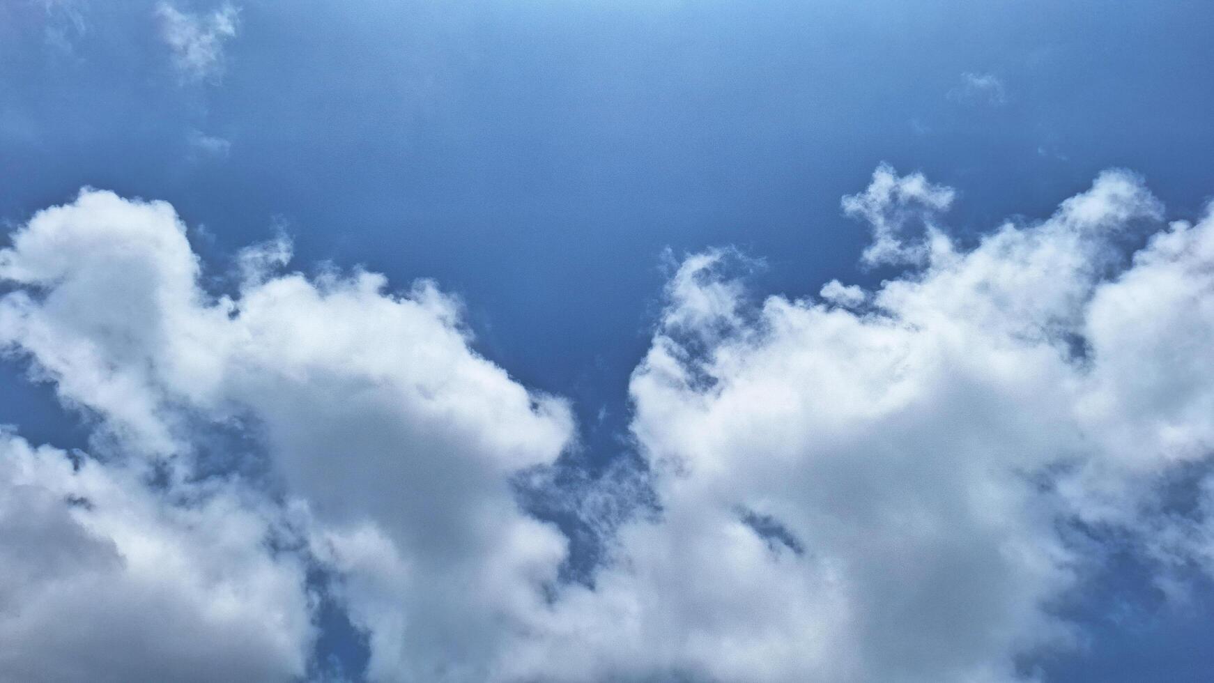 The beauty of a bright blue sky with white clouds that resemble cotton. These clouds provide a lovely contrast with the blue background, creating a refreshing and peaceful atmosphere. photo