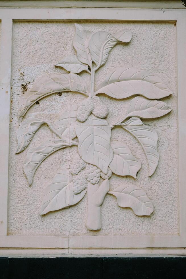 Bogor, November 9, 2024 Stone relief of tropical leaves with textured details in a rectangular frame photo