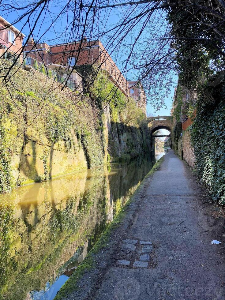 A canal with a bridge and trees on either side photo