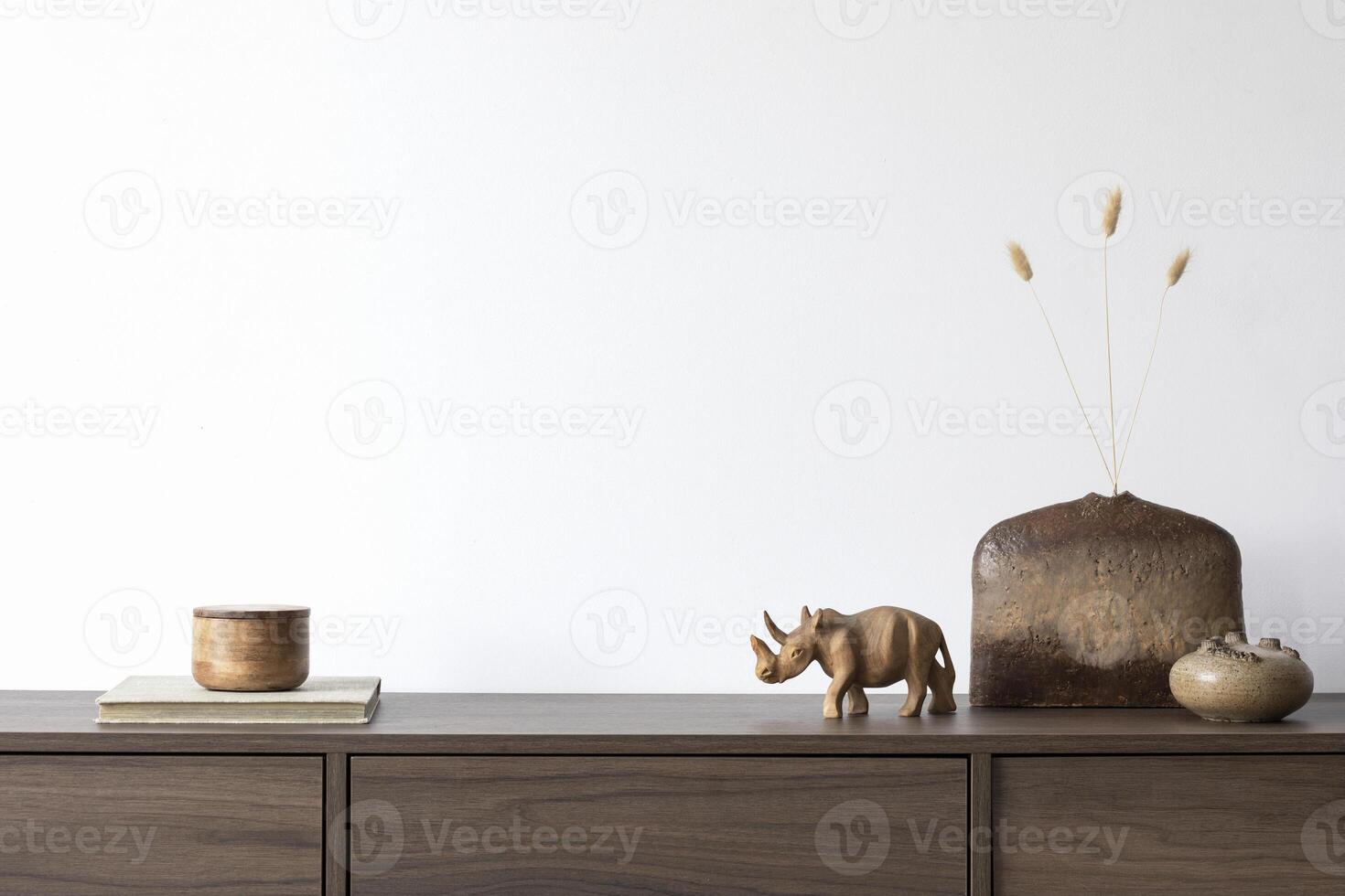 Creative minimalistic composition with white wall and stylish small personal accessories on wooden commode. Copy space. photo