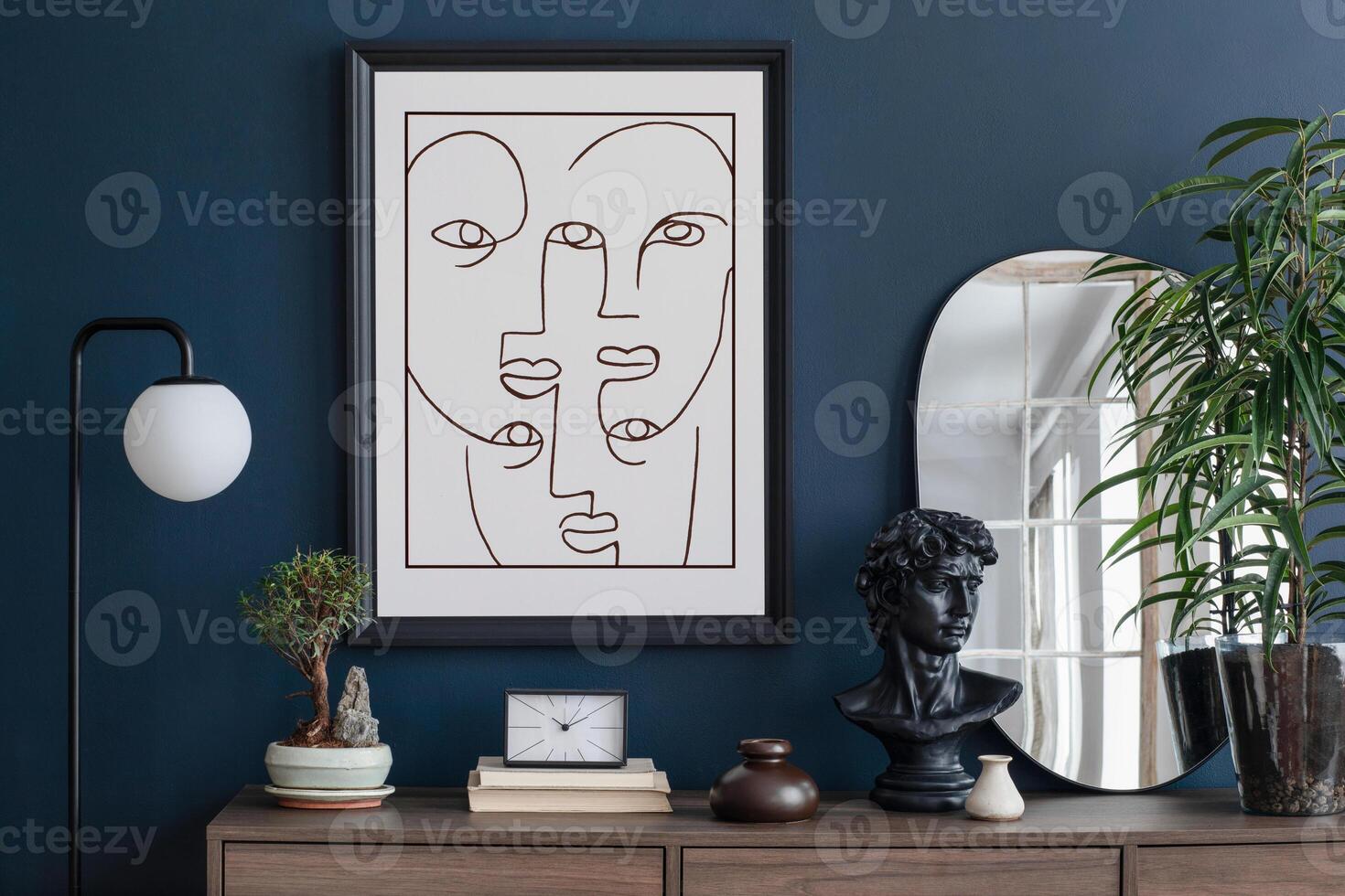 Creative composition of modern living room interior design with mockup poster frame, wooden commode, mirror and elegant personal accessories. Blue wall. Home staging. Template. Copy space. photo