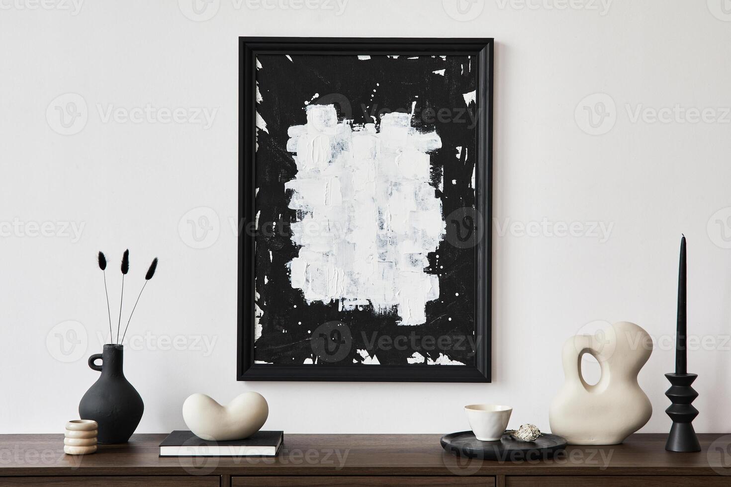 Creative composition of modern living room interior design with mock up poster frame, brown commode, vases, candlestick and personal accessories. White wall. Copy space. photo