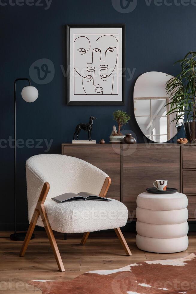 Elegant modern living room interior design with fluffy armchair, pouf, wooden commode, mock up poster frame and modern home accessories. Blue wall. Template. Copy space photo