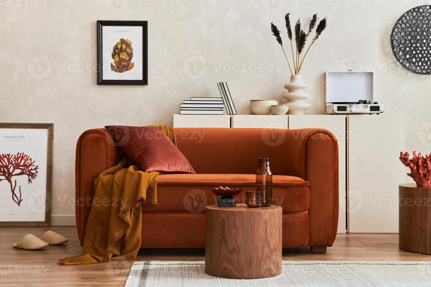 Creative composition of stylish living room interior with mock up poster frames, orange sofa, beige commode, coffee table and stylish personal accessories. Artistic space. photo