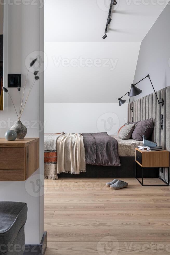 Minimalistic composition of bedroom interior with velvet bed, shelf, design lamp, shelf and elegant accessories. Beautiful bed sheets, blanket and pillow. Template. Design home decor photo