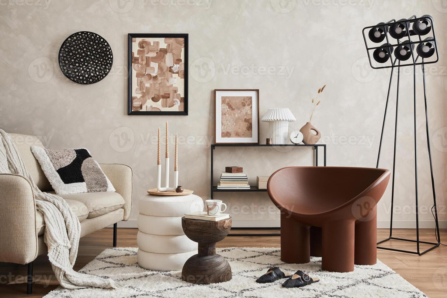Elegant interior of living room with beige sofa, black console, brown armchair, industrial lamp, mock up poster frame and stylish home decorations. Copy space. Template. photo