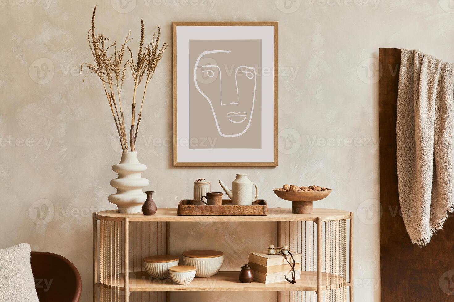 Creative interior composition with design wooden console, mock up poster frame, armchair and stylish personal accessories such as teapot, vase and books. Template. photo
